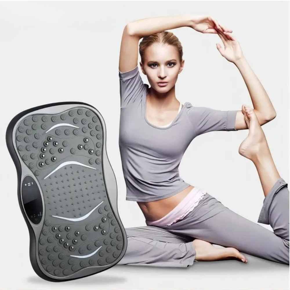 woman stretching in a yoga pose next to a vibration foot massage board for home fitness